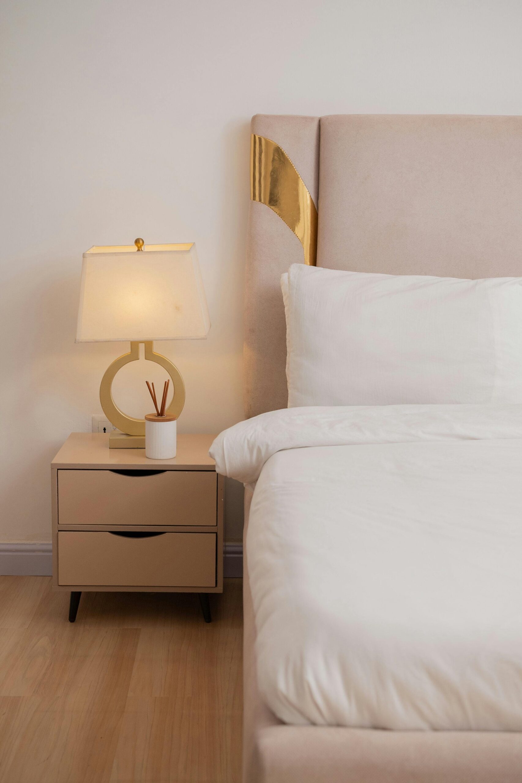 Elegant bedroom interior with a chic lamp on a bedside table, minimalist decor.